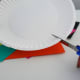 Cut out the snowman’s head from one of the paper plates. Make sure to cut just outside the smallest center circle of the plate.