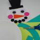          Cut out a long piece and two small pieces out of any color cardstock to create the scarf. Then glue the pieces to the second paper plate (body of the snowman). 