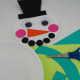 Cut out a long piece and two small pieces out of any color cardstock to create the scarf. Then glue the pieces to the second paper plate (body of the snowman).