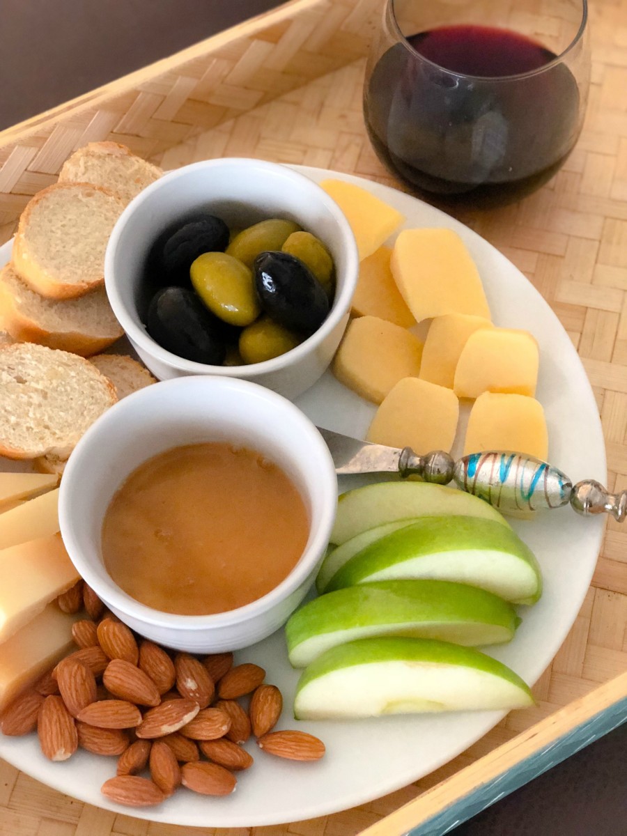 cheese plate, baguette, olives, almonds, honey and wine