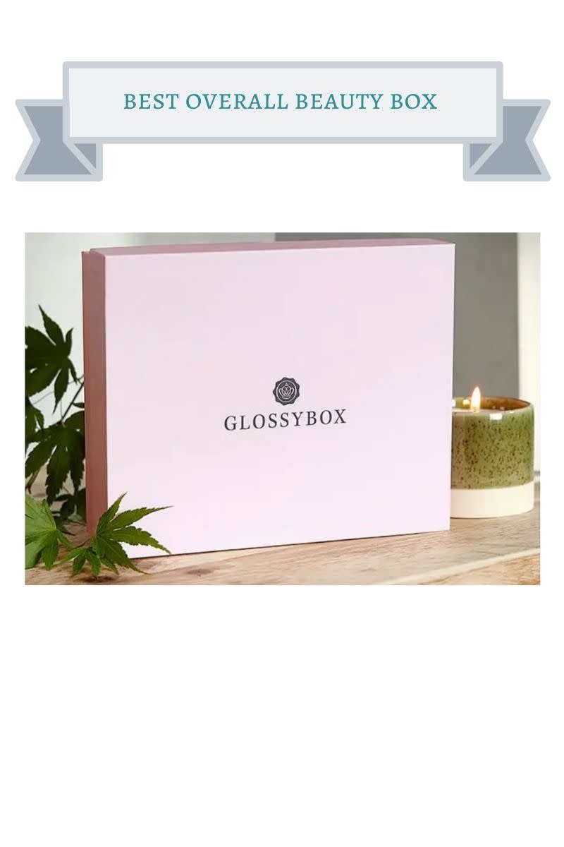 pink box on wooden table next to green leafy plant and green and ivory candle