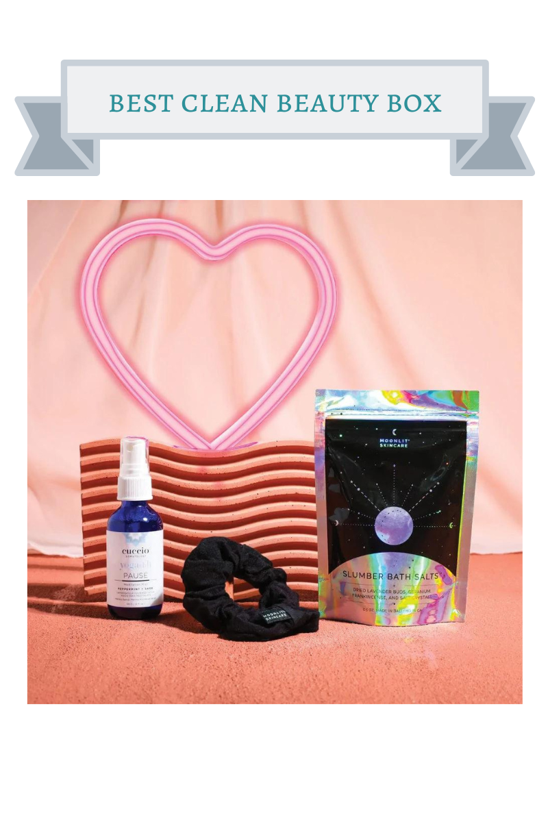 blue bottle, black and hologram silver bath salts pouch and black scrunchie in front of pink background and pink heart
