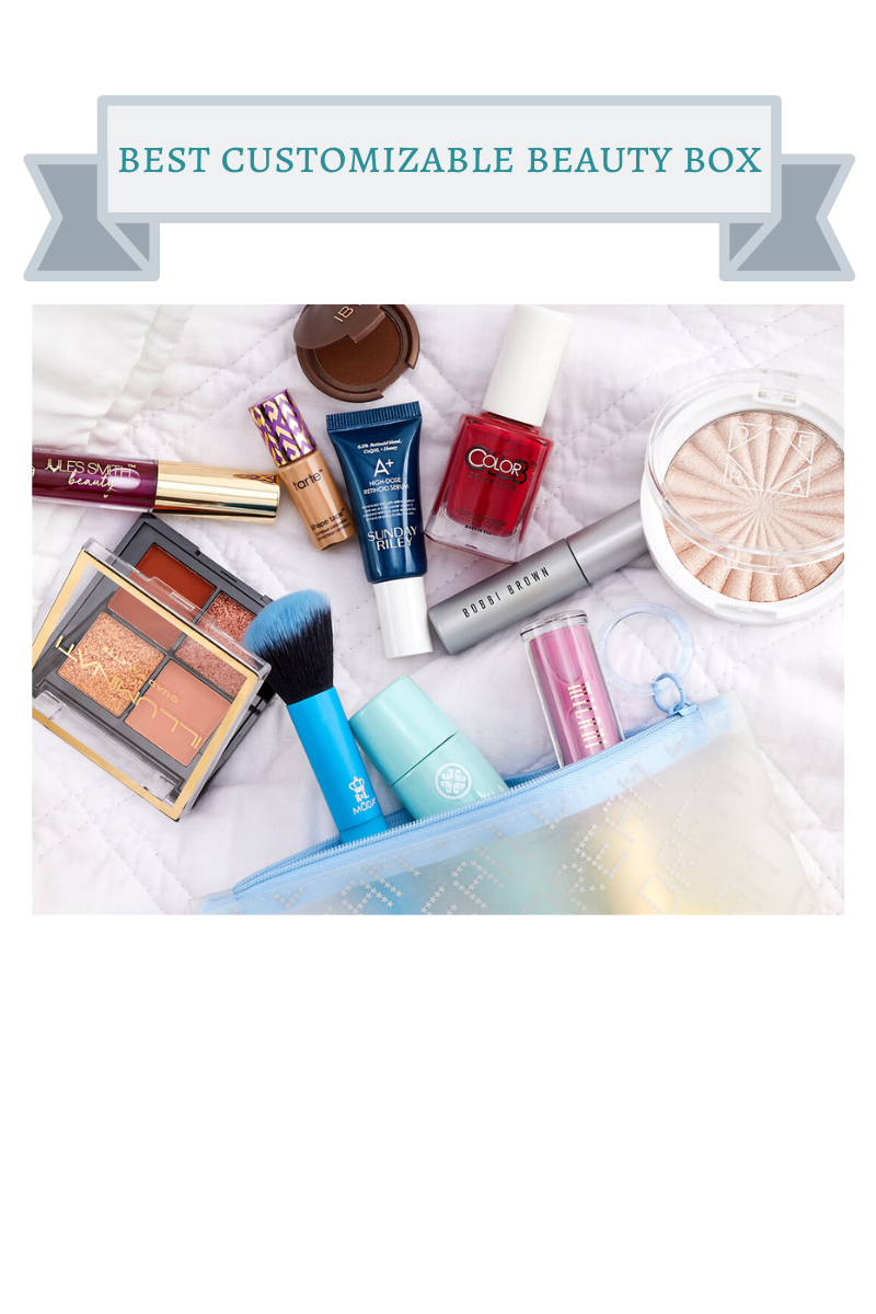 bronze eyeshadow palette, highlighter compact, red nail polish, pink lip gloss, blue makeup brush, silver mascara in clear and light blue bag on white blanket