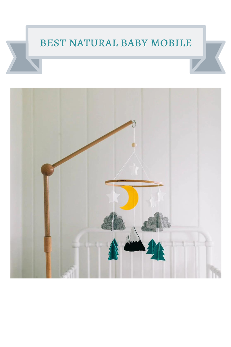 natural wood baby mobile with white stars, yellow moon, gray clouds, green evergreen trees and white snow capped black mountains